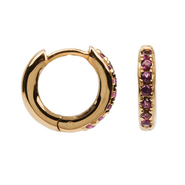 The creole earrings in gold and ruby colour from the brand ALL THE LUCK IN THE WORLD