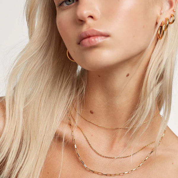 Model wearing the Essential necklaces set in gold colour from the brand P D PAOLA