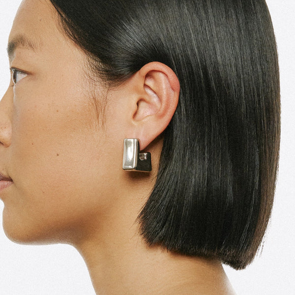 Model wearing the Cubo earrings in silver from the brand PANCONESI